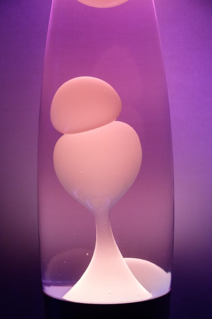 a lava lamp with white and purple color on a gradient background